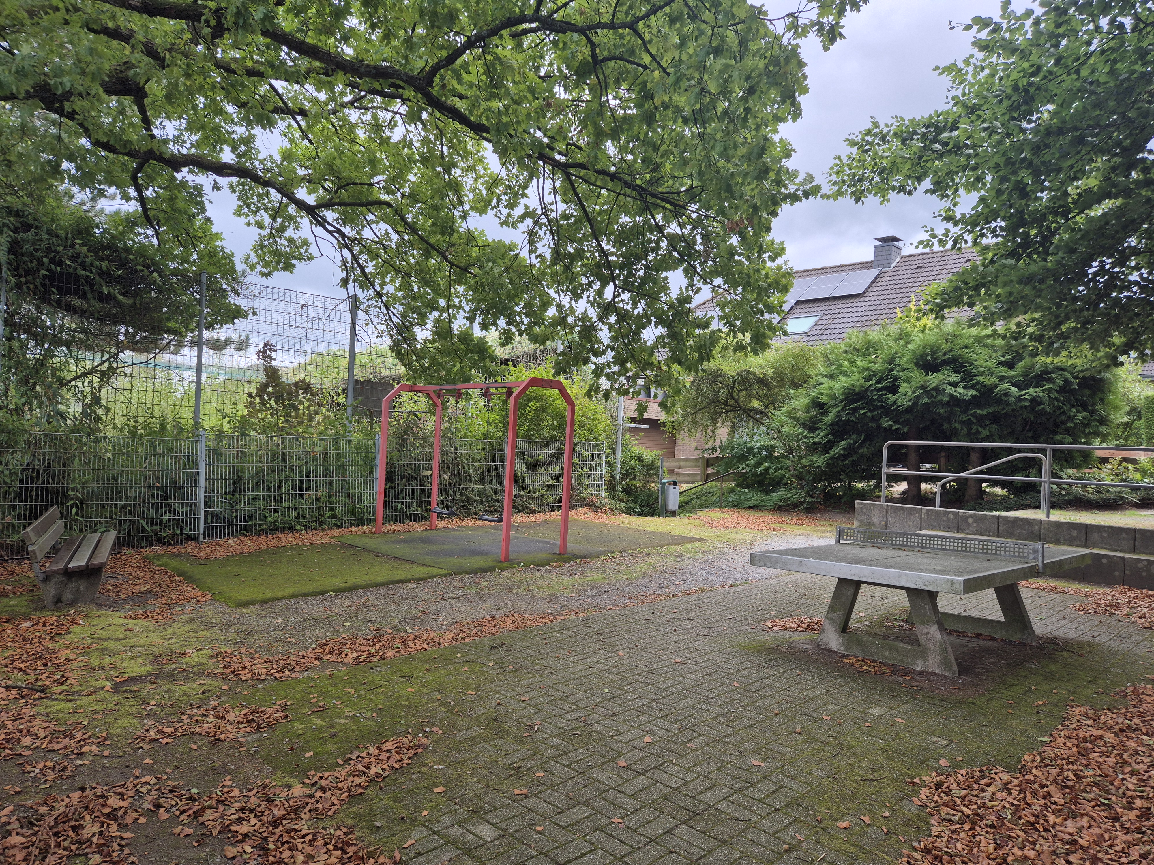 Heutiger Zustand des Spielplatzes "Zum Lohbusch" mit alter Schaukel, Tischtennisplatte und Sitzbank